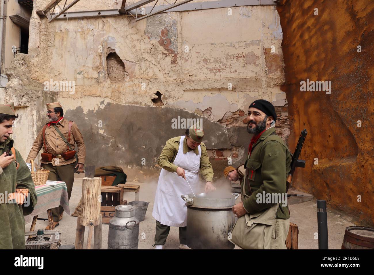 Spanish Civil War reenactment. Living historians recreate a kitchen at the rearguard, with cooks and soldiers. Hunger in war was lethal. Stock Photo