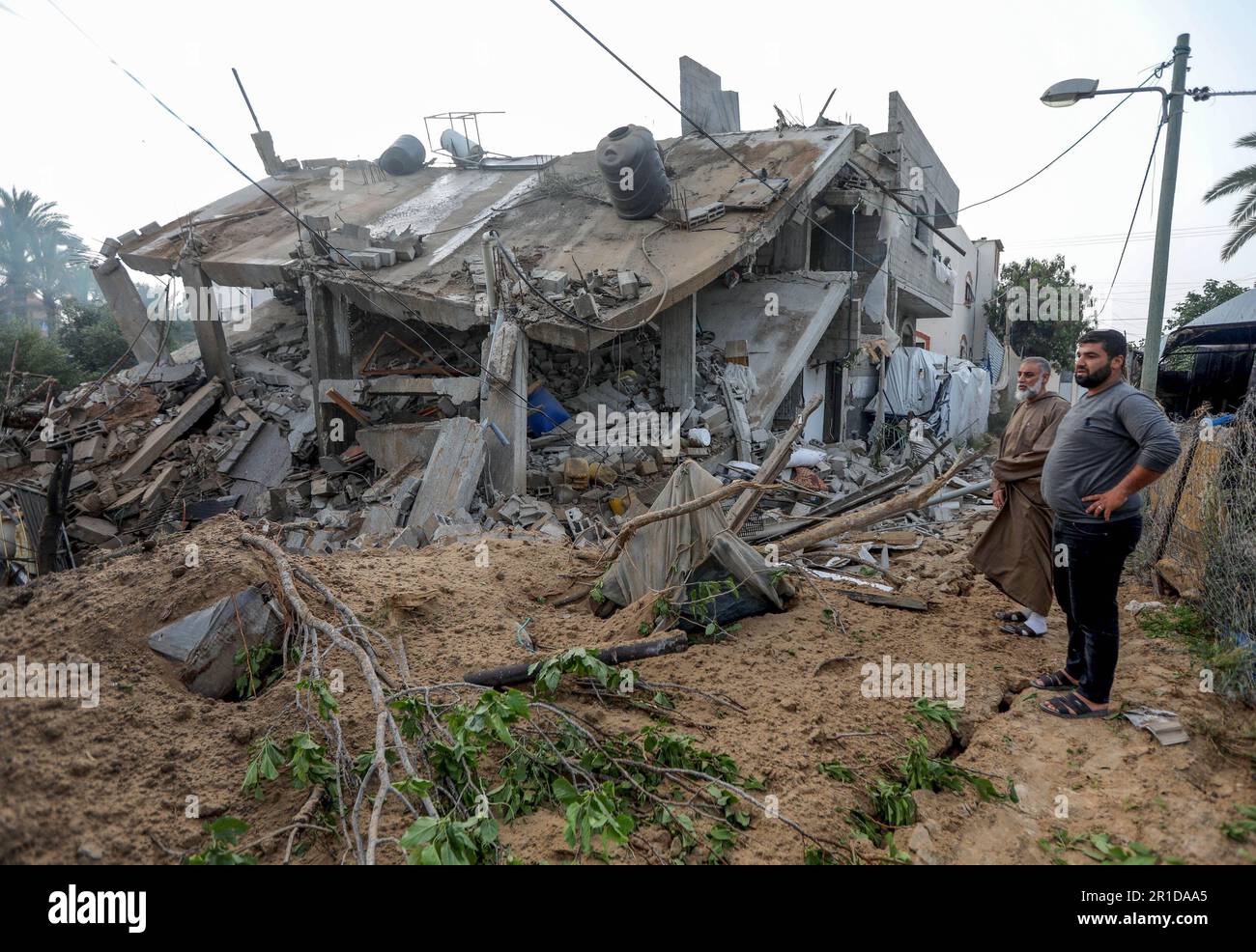 Gaza, Palestine. 12th May, 2023. Palestinians seen around a building hit by an Israeli air strike in Deir al-Balah, central Gaza Strip. (Photo by Yousef Masoud/SOPA Images/Sipa USA) Credit: Sipa USA/Alamy Live News Stock Photo