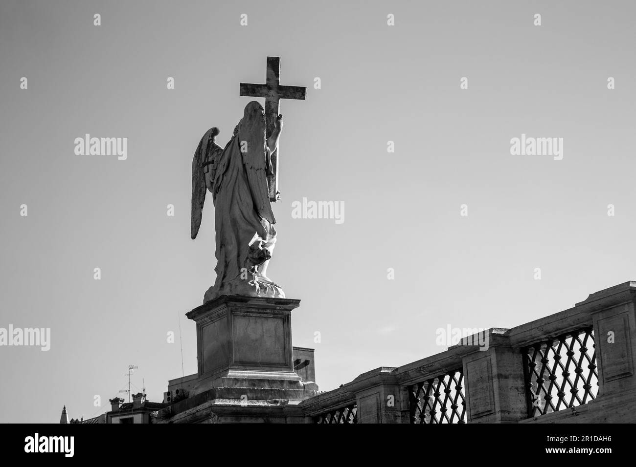 Black and white view of the statues an angel on a bridge with a cross on top. Rome, Italy Stock Photo