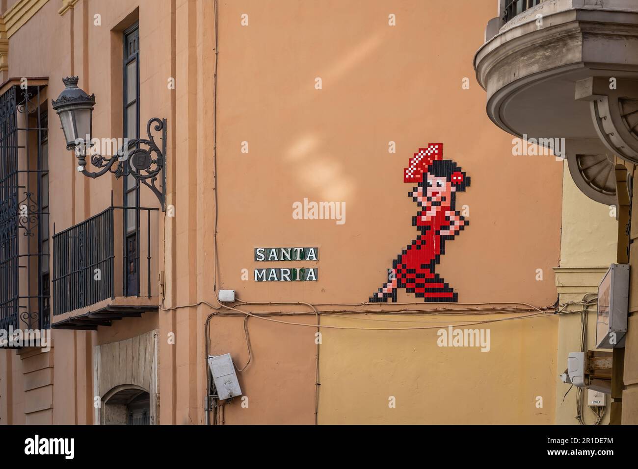 Santa Maria Street (Calle Santa Maria) with pixel flamenco dancer art by Invader - Malaga, Andalusia, Spain Stock Photo
