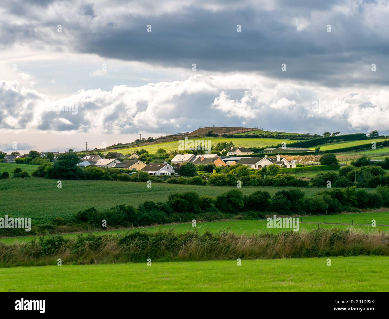 Sky with cumulus clouds over a Irish village on a summer evening. Irish settlement in County Cork, dramatic landscape. European countryside, rustic la Stock Photo