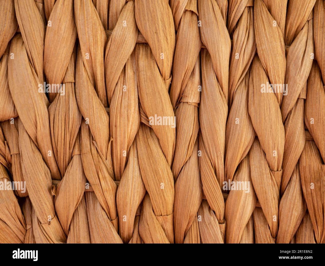 Twisted straw background from aquatic hyacinth, close up. Traditional handcraft weave Thai style pattern. Palm fiber place mat. Wicker or rattan Stock Photo