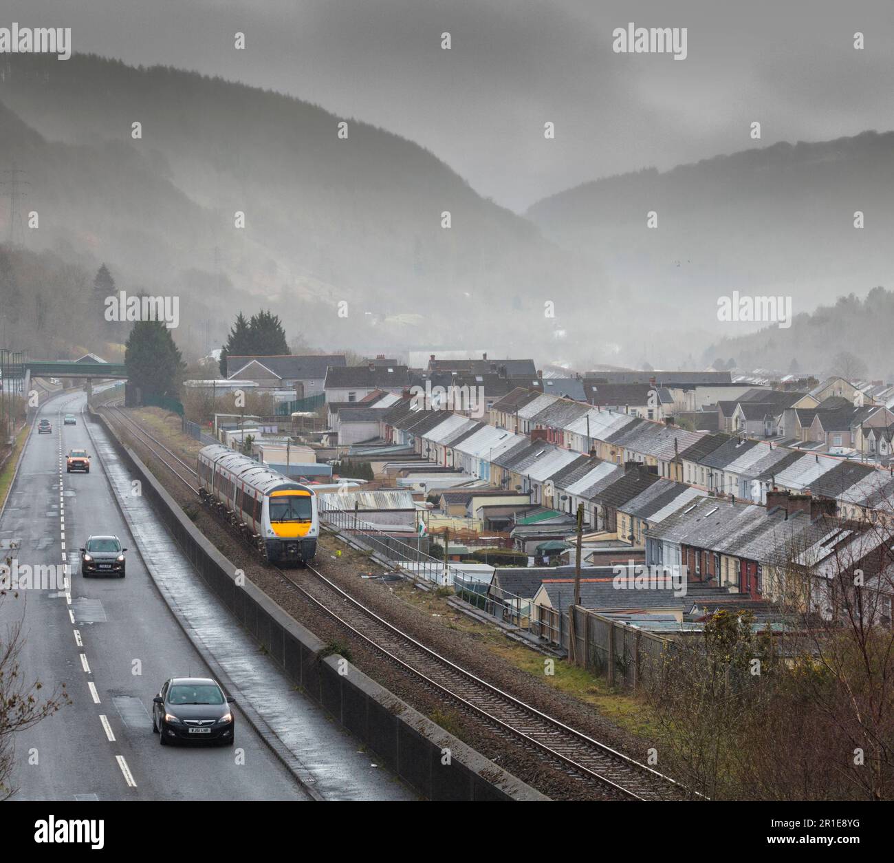 Transport For Wales class 170 turbostar train passing the rows of terraced houses as it passes