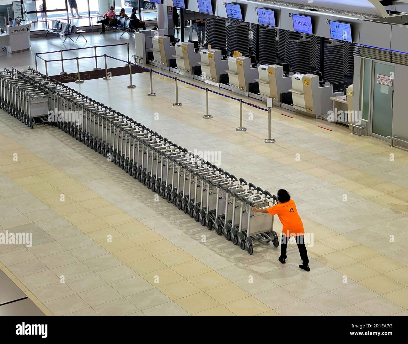 At the airport, workers push trollys to make them ready for passengers ...