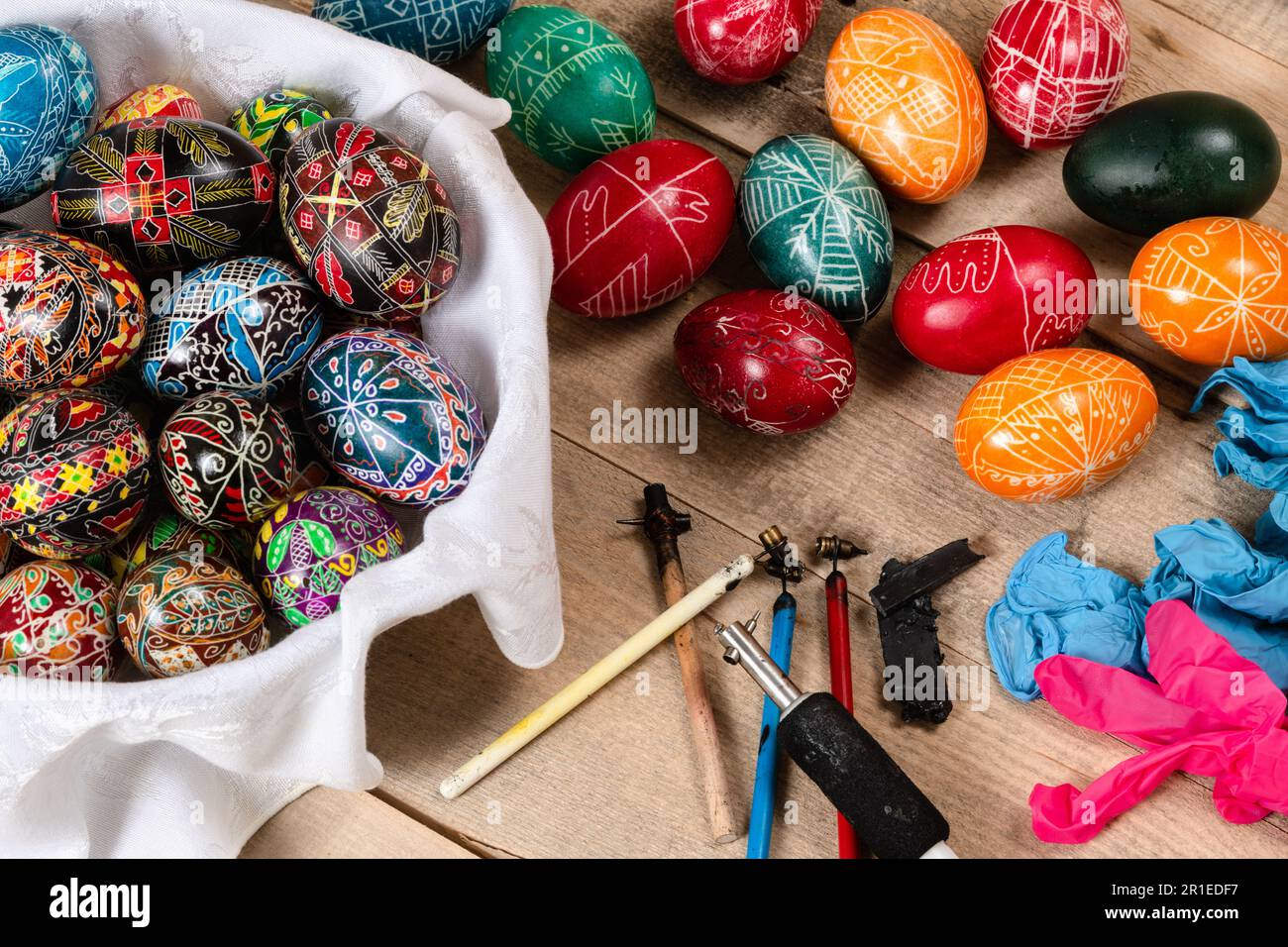 Hand painted painted Easter eggs and decorating materials for making Easter eggs. Painting Easter eggs with hot wax. Stock Photo