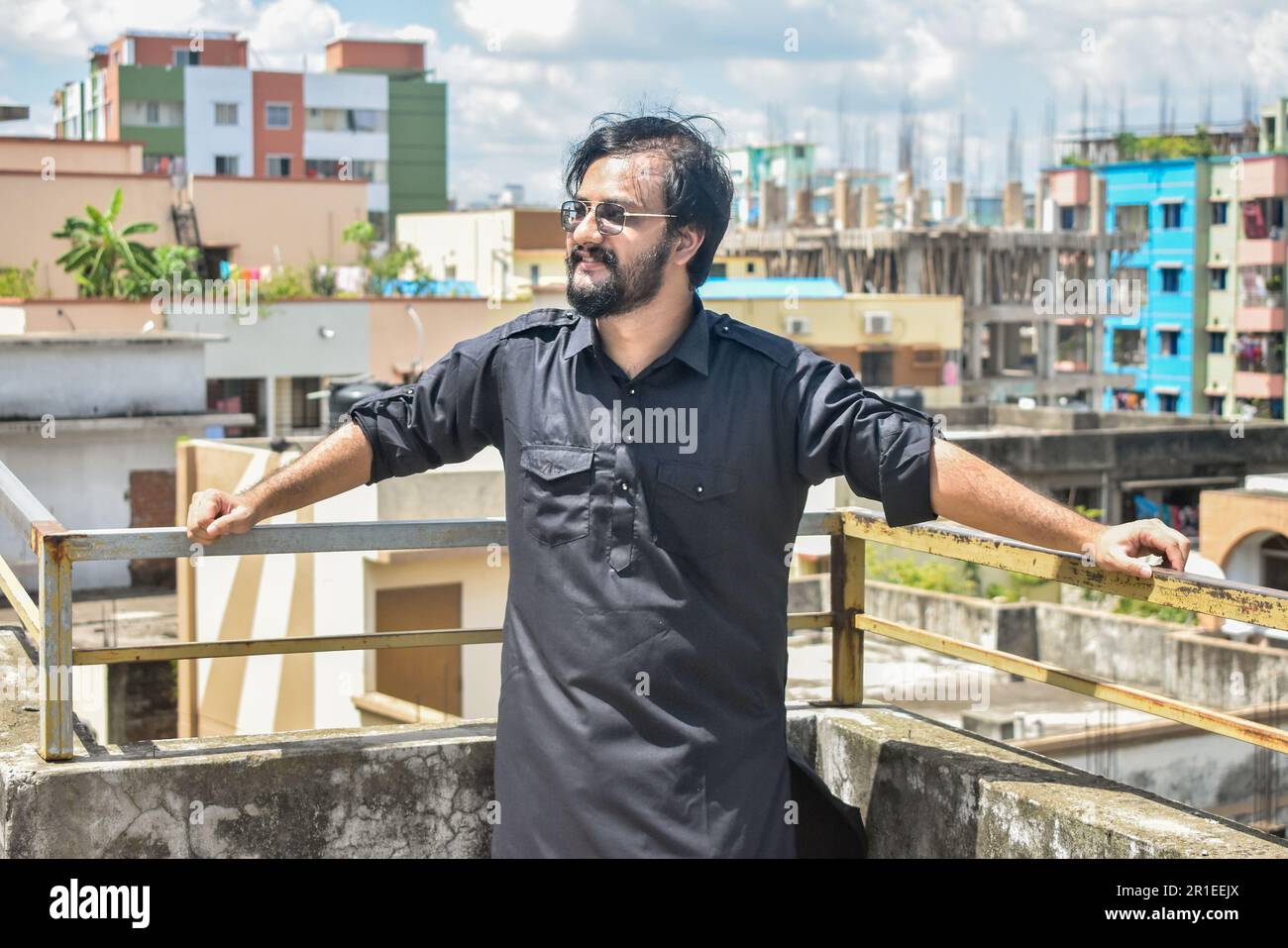 Handsome young man in black kabli panjabi dress standing on rooftop Stock Photo