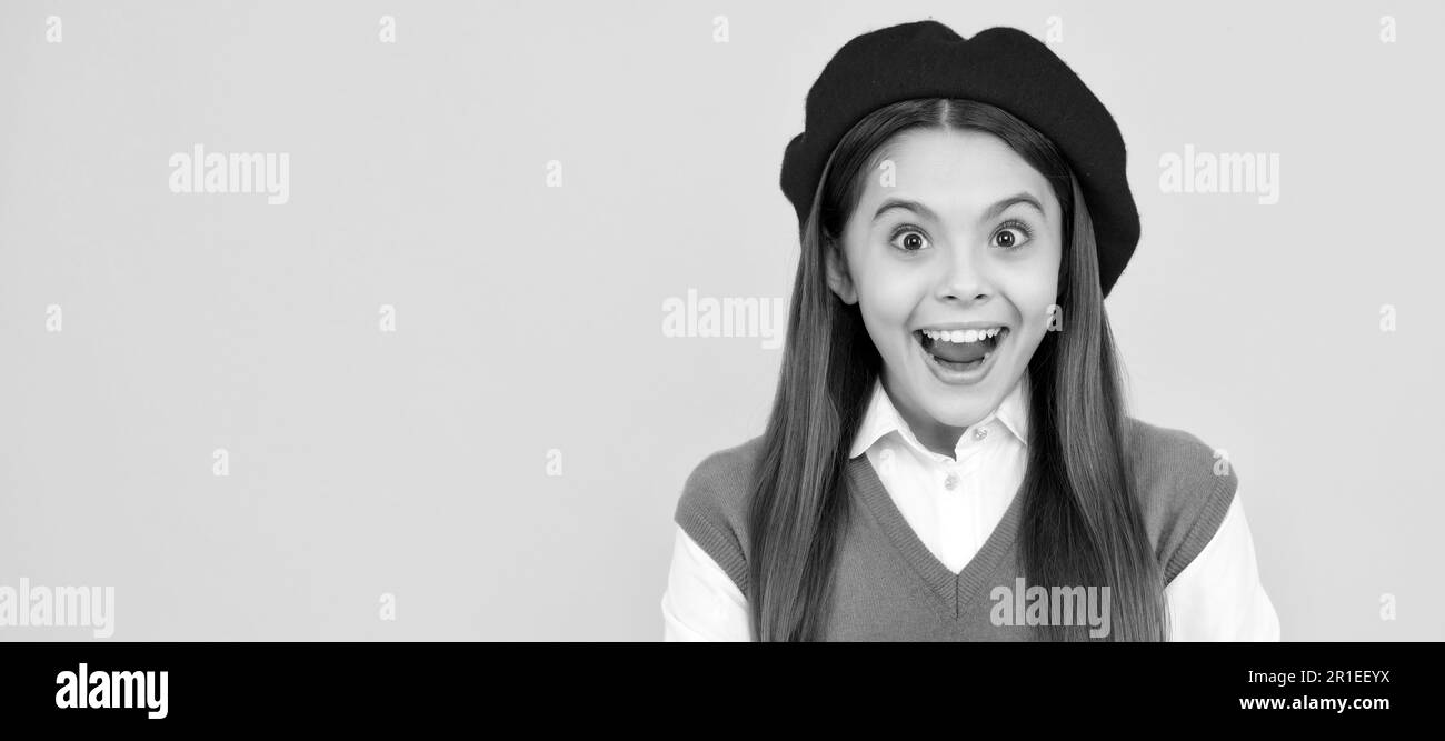 surprised teen school girl in french beret hold copybook on yellow background. Child face, horizontal poster, teenager girl isolated portrait, banner Stock Photo