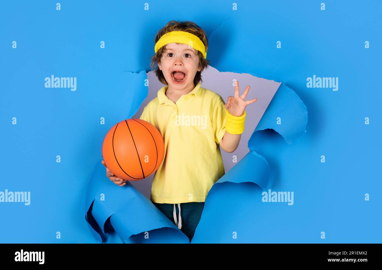 Active sport lifestyle. Surprised child boy with basketball ball shows