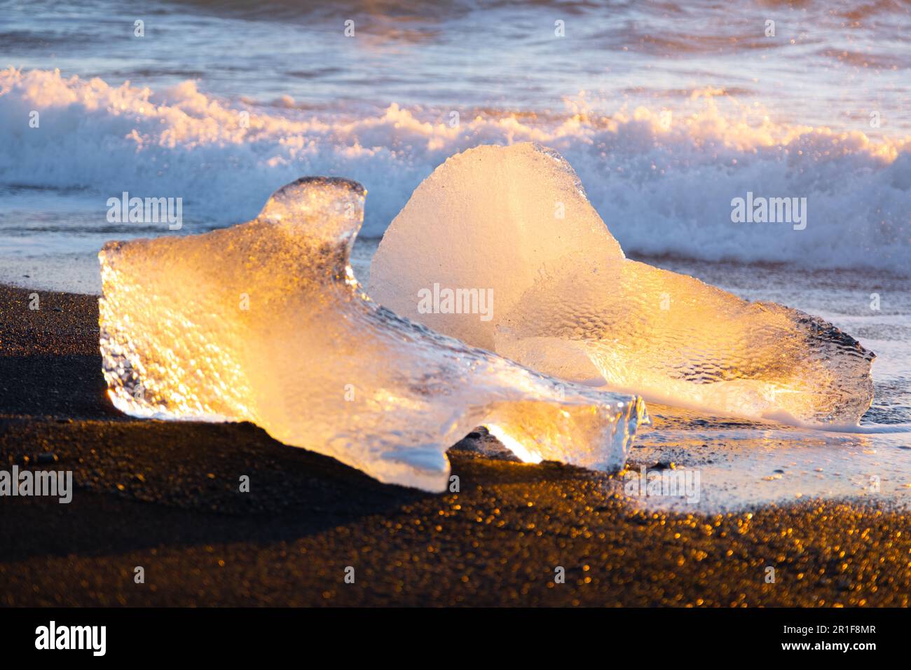 Icebergs Shining on Black Volcanic Sand at Sunset. Clear Ice Crashed by ...