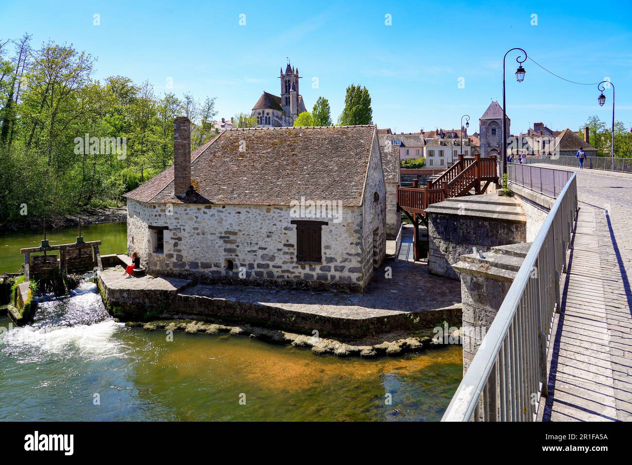 Water mill built on a dam over the river Loing in the medieval town of Moret-sur-Loing in Seine et Marne, France Stock Photo