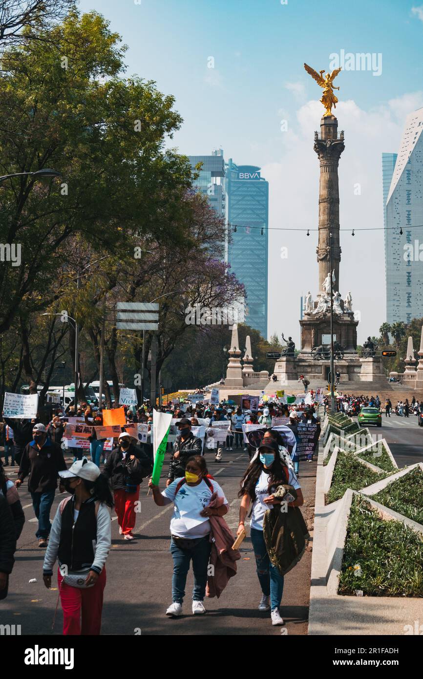 Protestors march down Av. Paseo de la Reforma in Mexico City, Mexico. The golden Angel of Independence statue can be seen behind Stock Photo