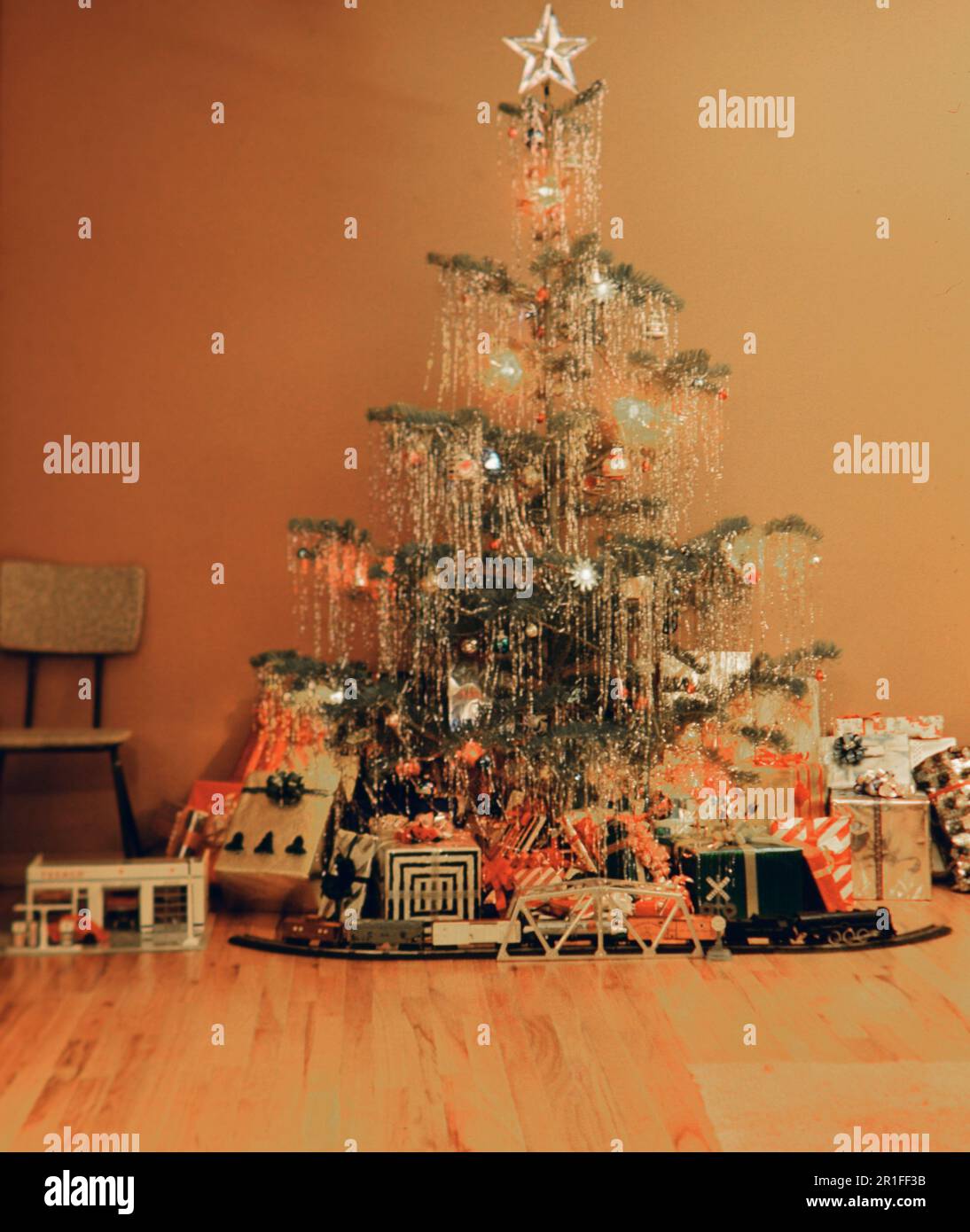 A decorated Christmas tree with presents underneath it, standing in a