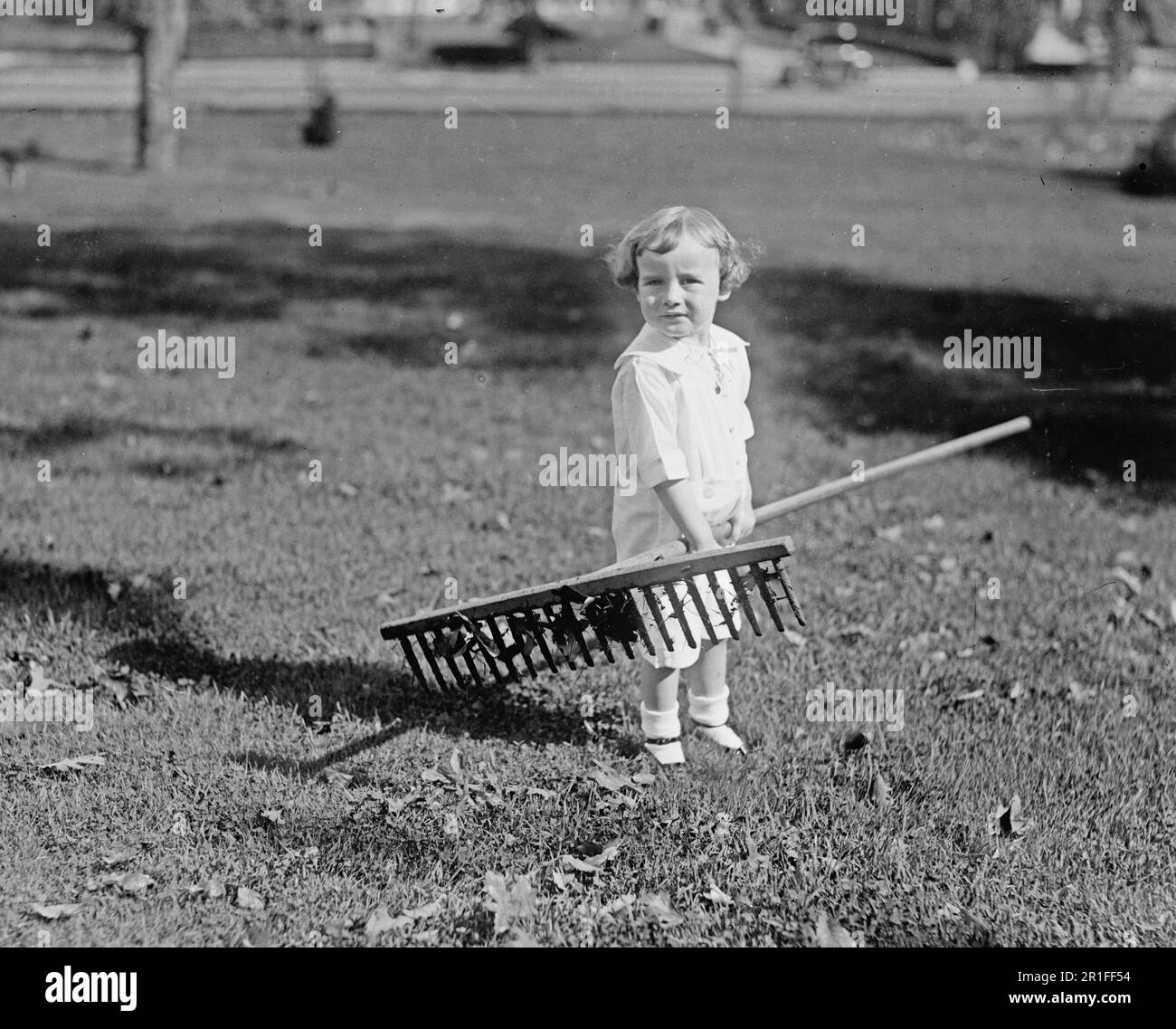 Archival Photo: A little boy holding a rake ca. 1918-1920 Stock Photo