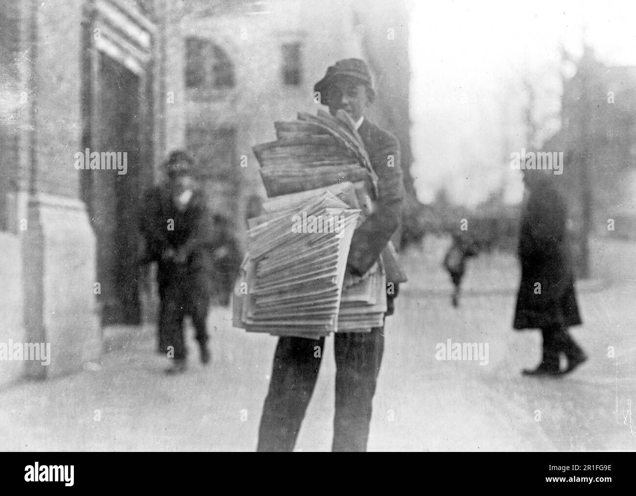 Archival Photo: Newsboy on a city street ca. 1909-1920 Stock Photo