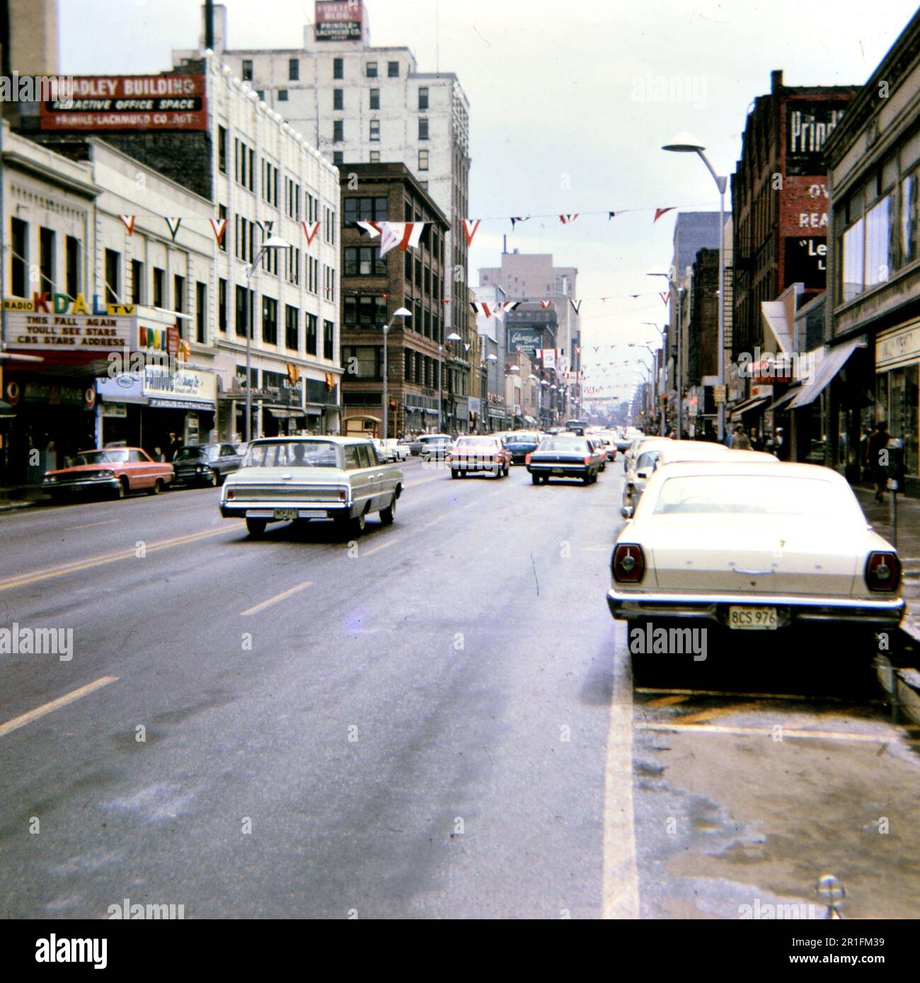 Cars driving down a street in downtown Duluth Minnesota (possibly Superior Street) ca. 1966