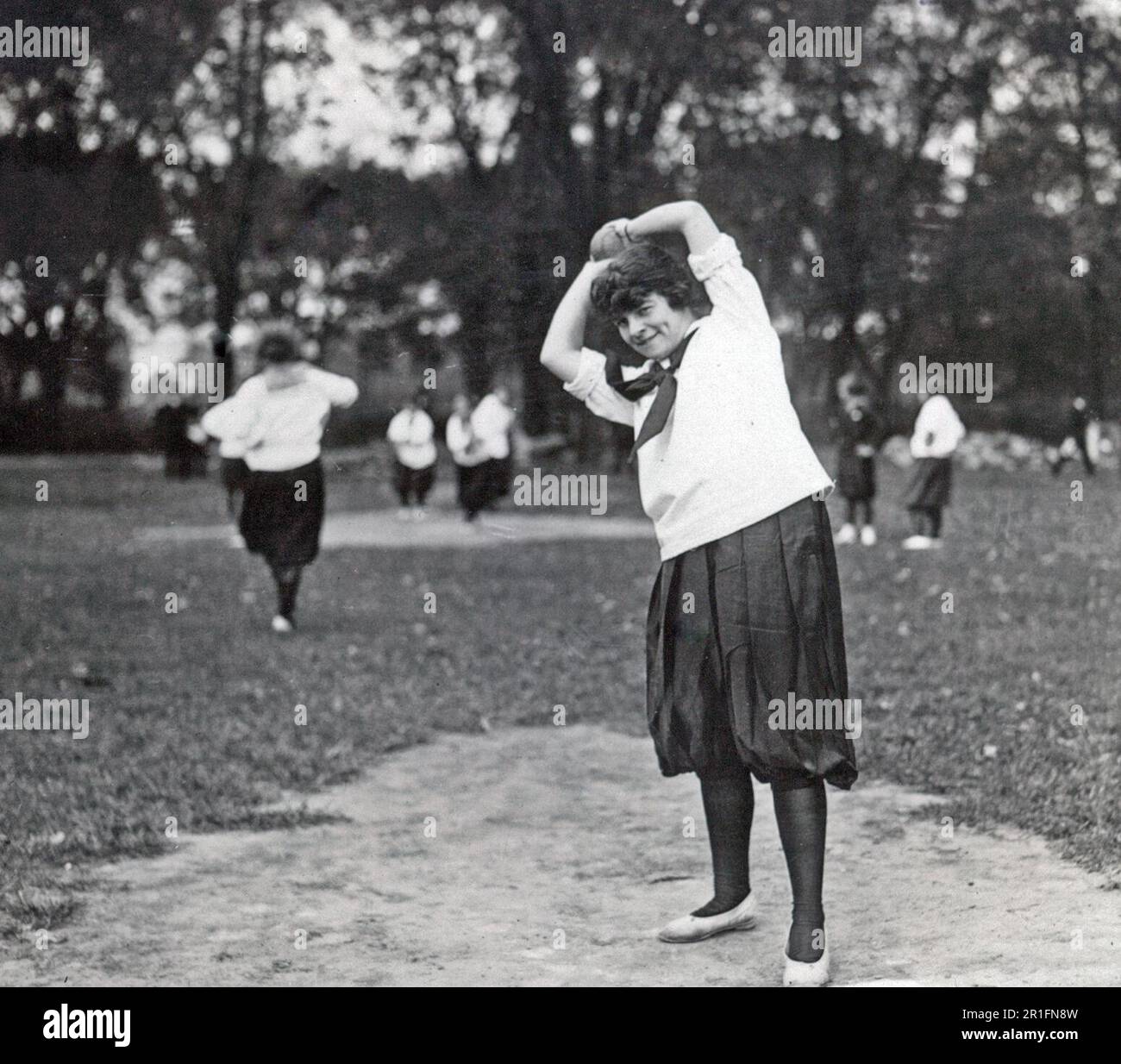 Archival Photo: A women's softball baseball game showing a woman on the pitcher's mound about to pitch the ball ca. 1910s or 1920s Stock Photo