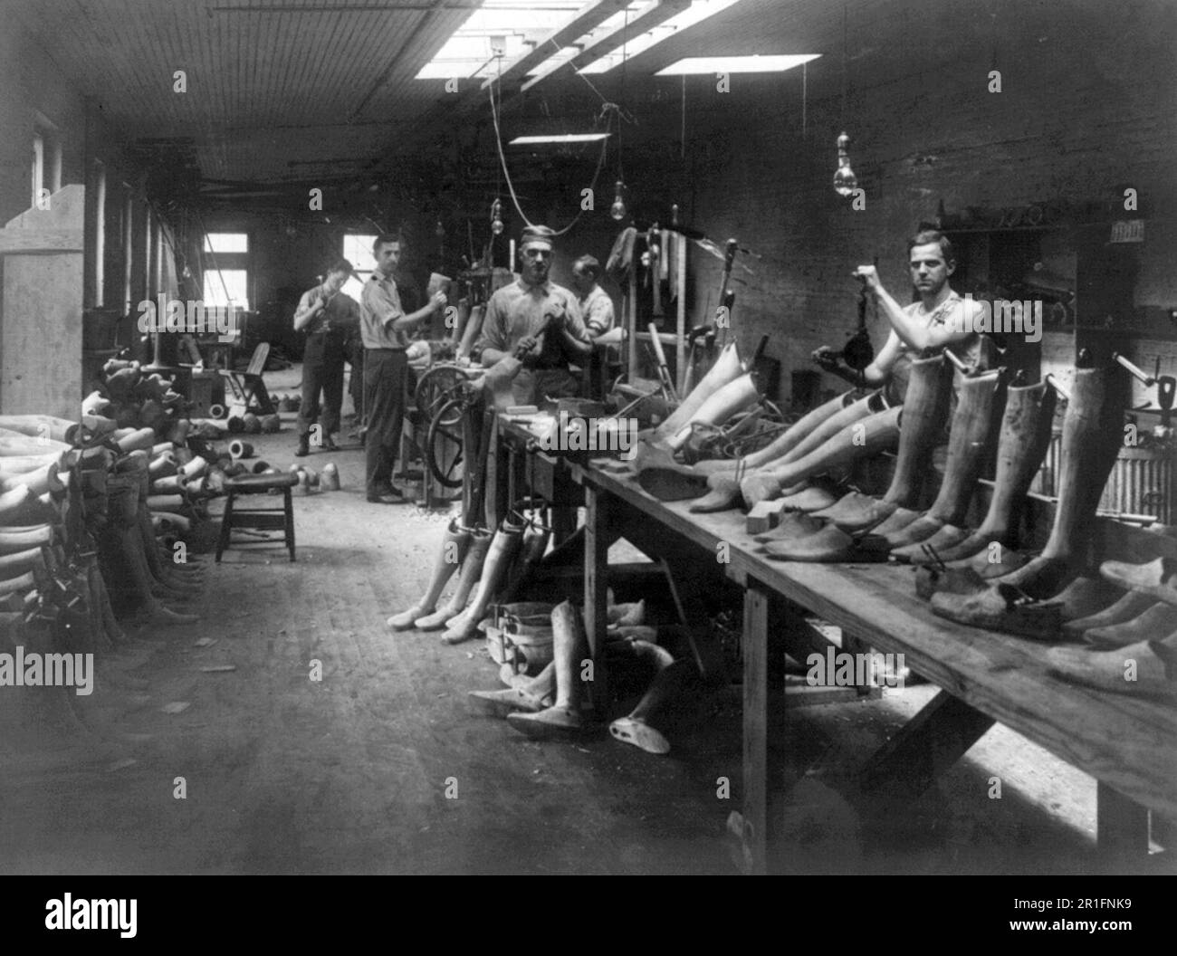 Archival Photo: Men at work [making artificial legs] in the J.E. Hangar shop, a manufacturer of artificial limbs ca. 1916 Stock Photo
