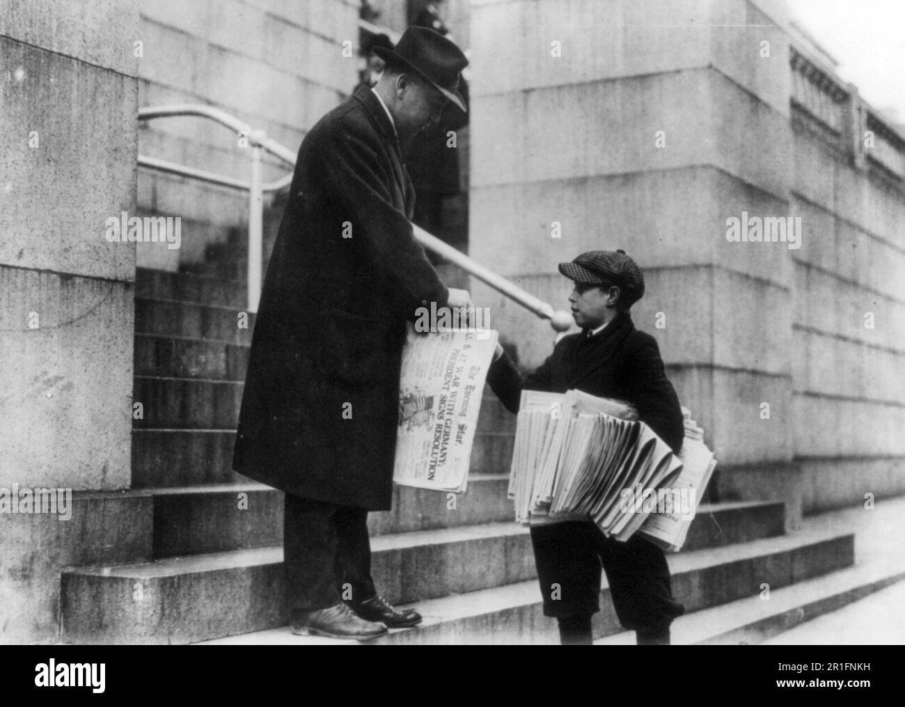 Archival Photo: Man buying The Evening Star from newsboy, Washington, D.C. - headline reads 'U.S. at War with Germany' ca. 1917 Stock Photo