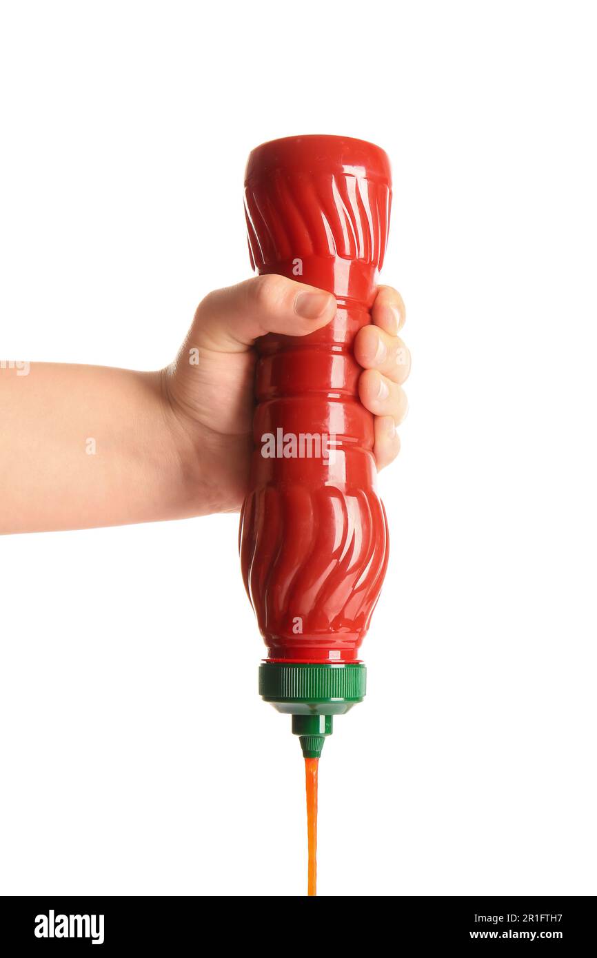 Hand holding ketchup bottle upside down and squeezing on white background Stock Photo Alamy