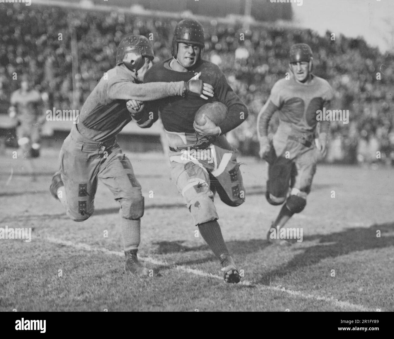 Archival Photo: Running back with the football, about to be tackled ca. 1920s Stock Photo