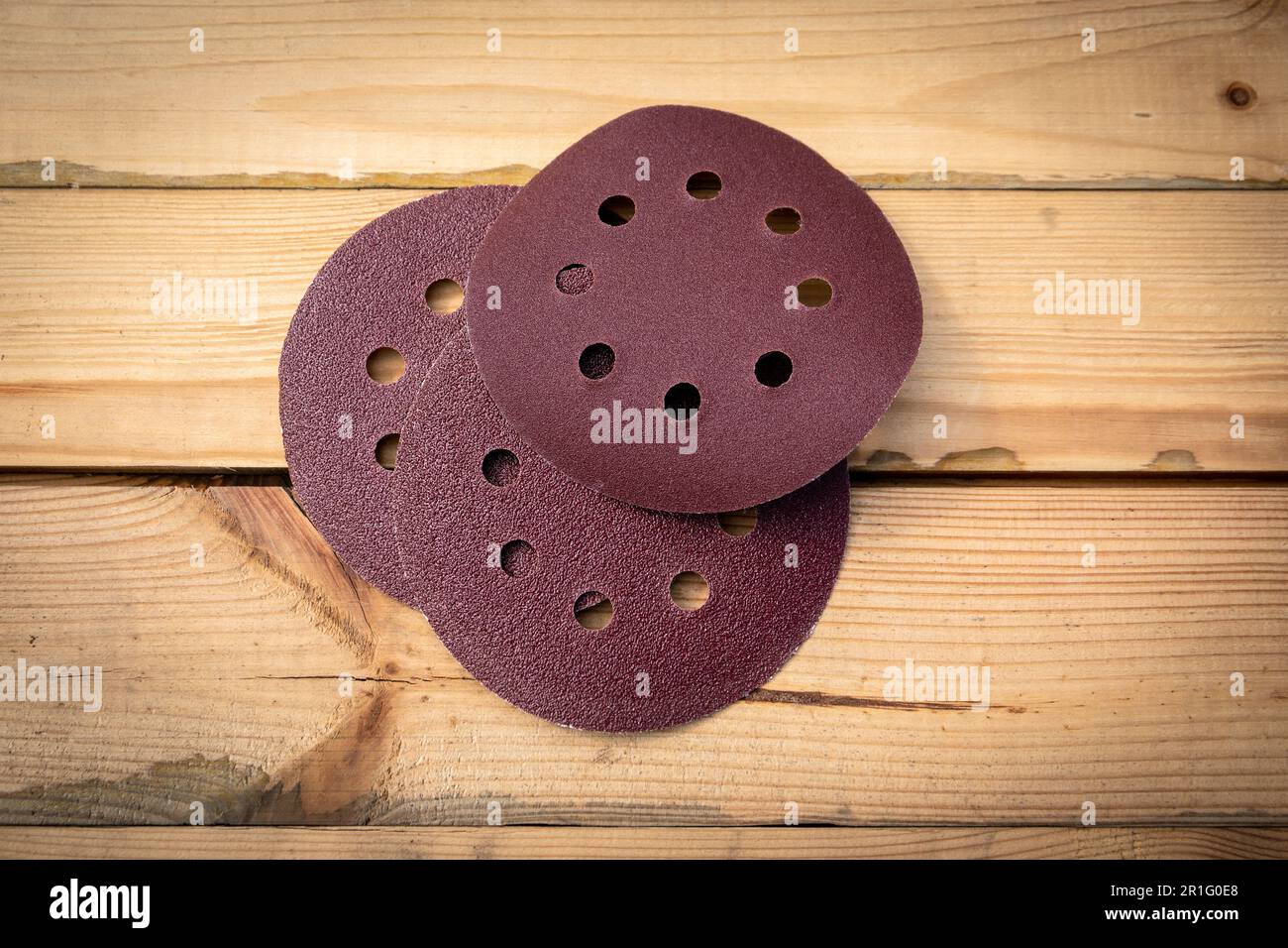 Round sandpaper discs for orbital sander. Wooden background Stock Photo