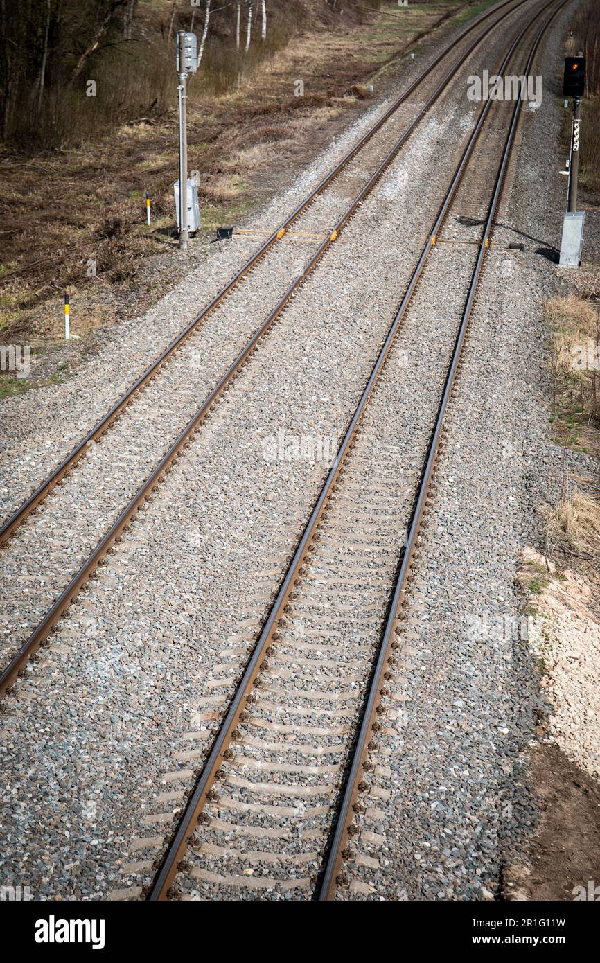 Two sets of railroad tracks run straight and parallel and two traffic