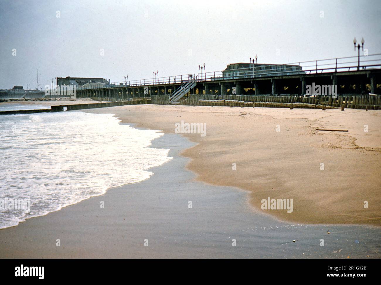 Surf hitting the beach near the boardwalk in Long Branch, New Jersey ca. 1955 Stock Photo