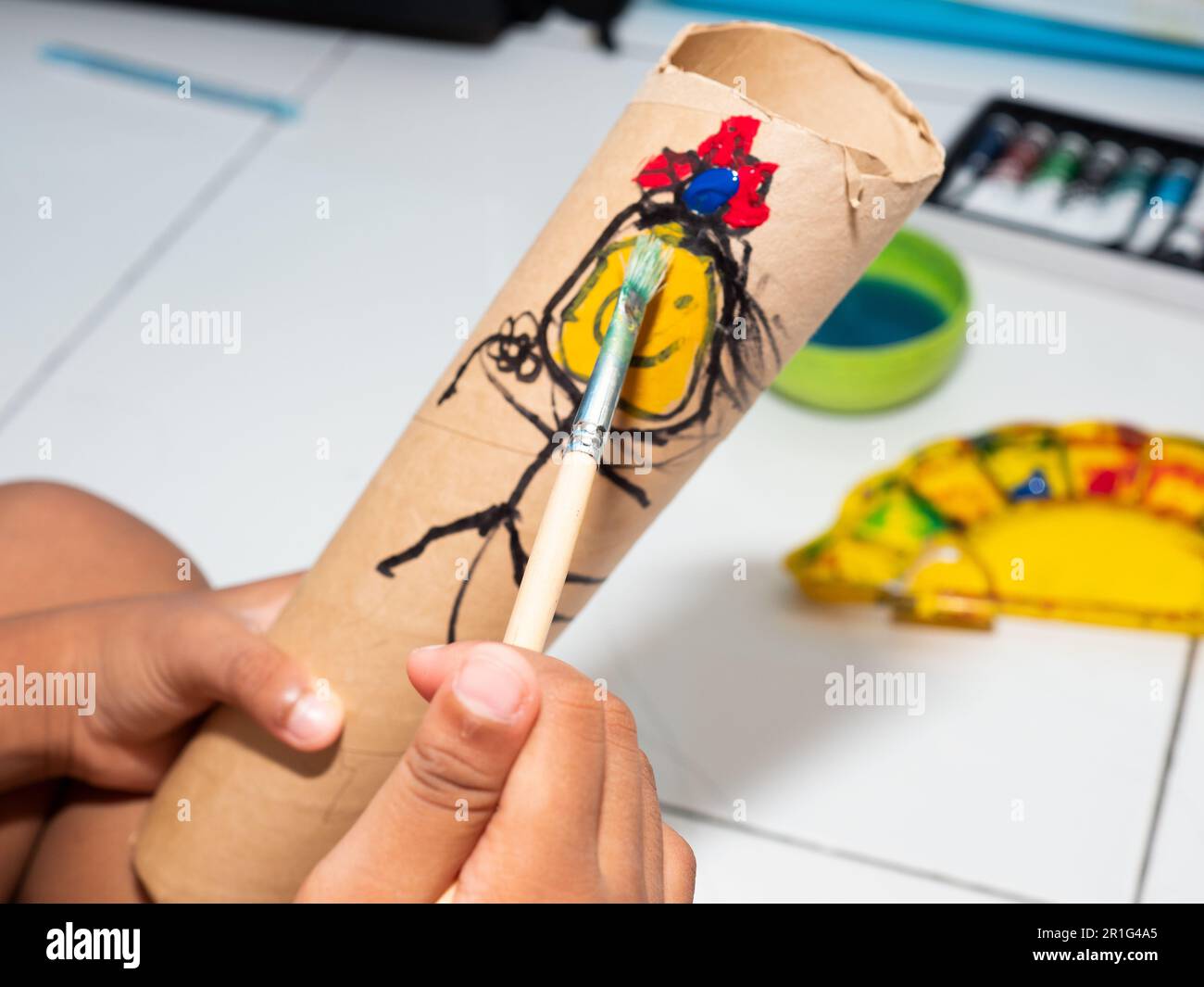 Kids painting on a paper tube Stock Photo