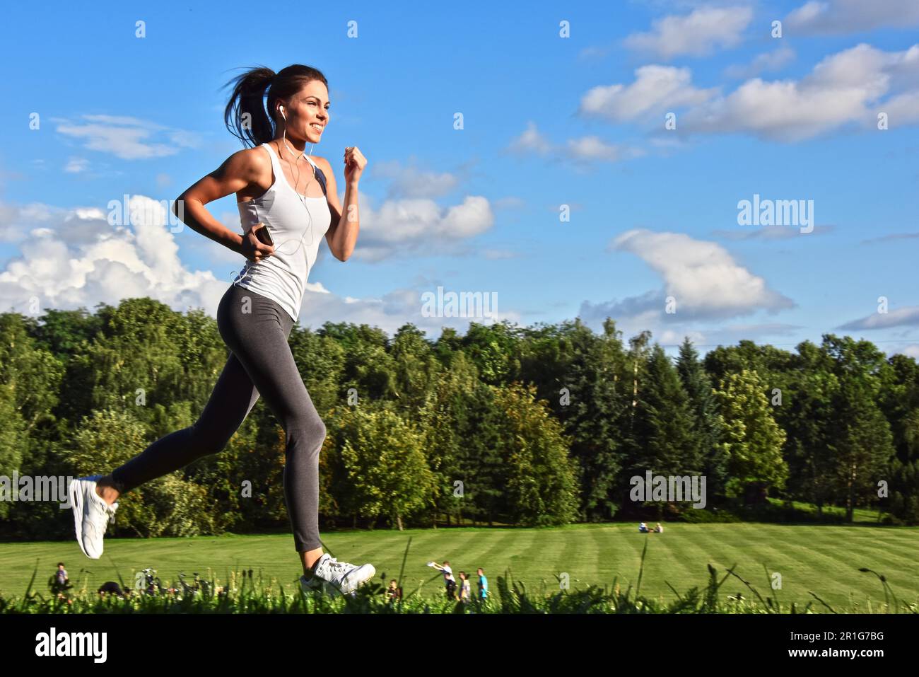 Young woman running in the park during sport training Stock Photo