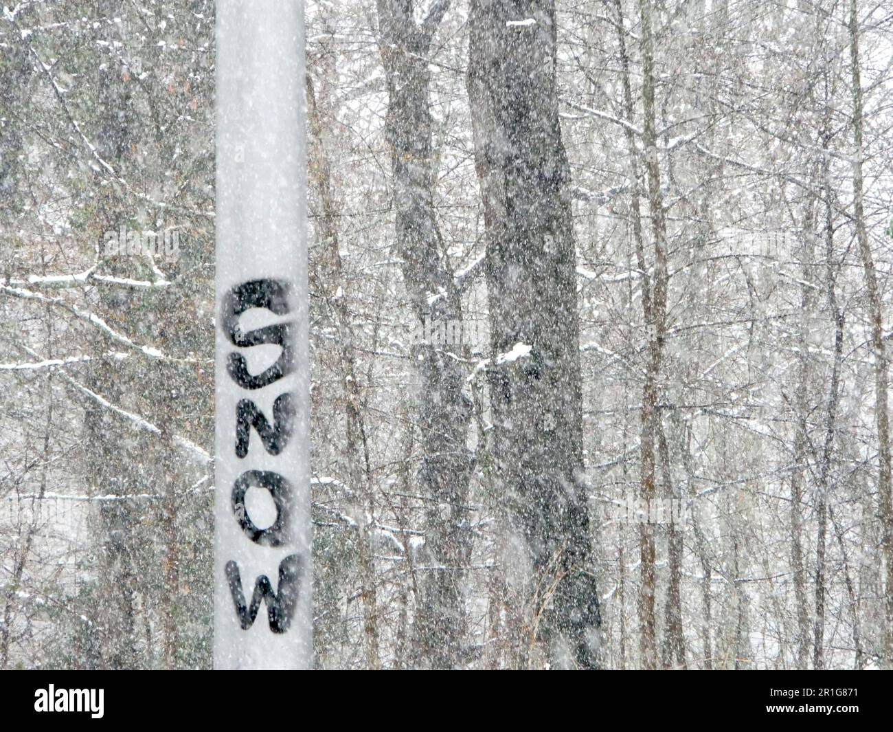 metallic post with snow graffiti in snowing weather Stock Photo