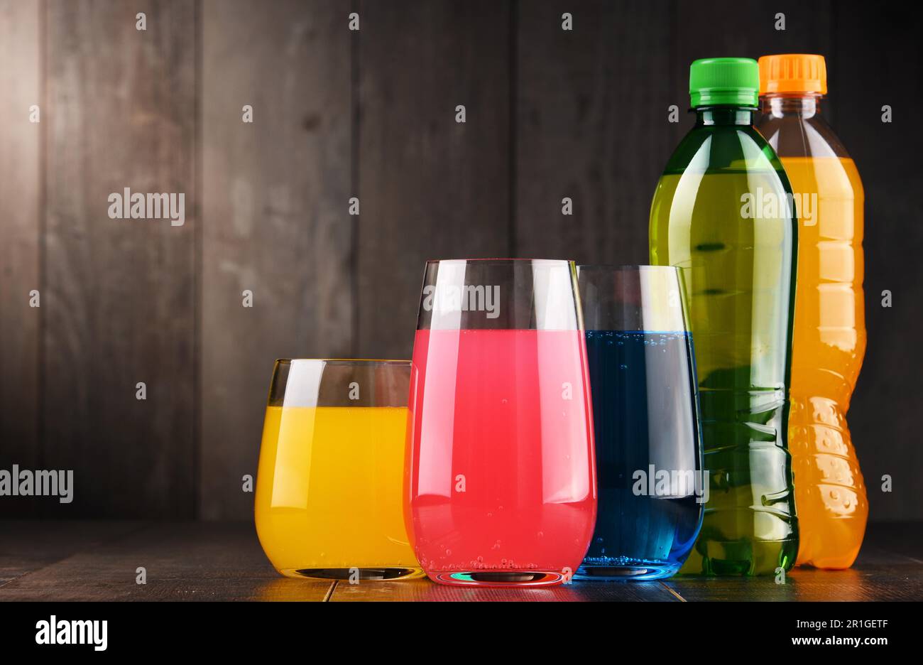 Glasses and bottles of assorted carbonated soft drinks in variety of colors Stock Photo