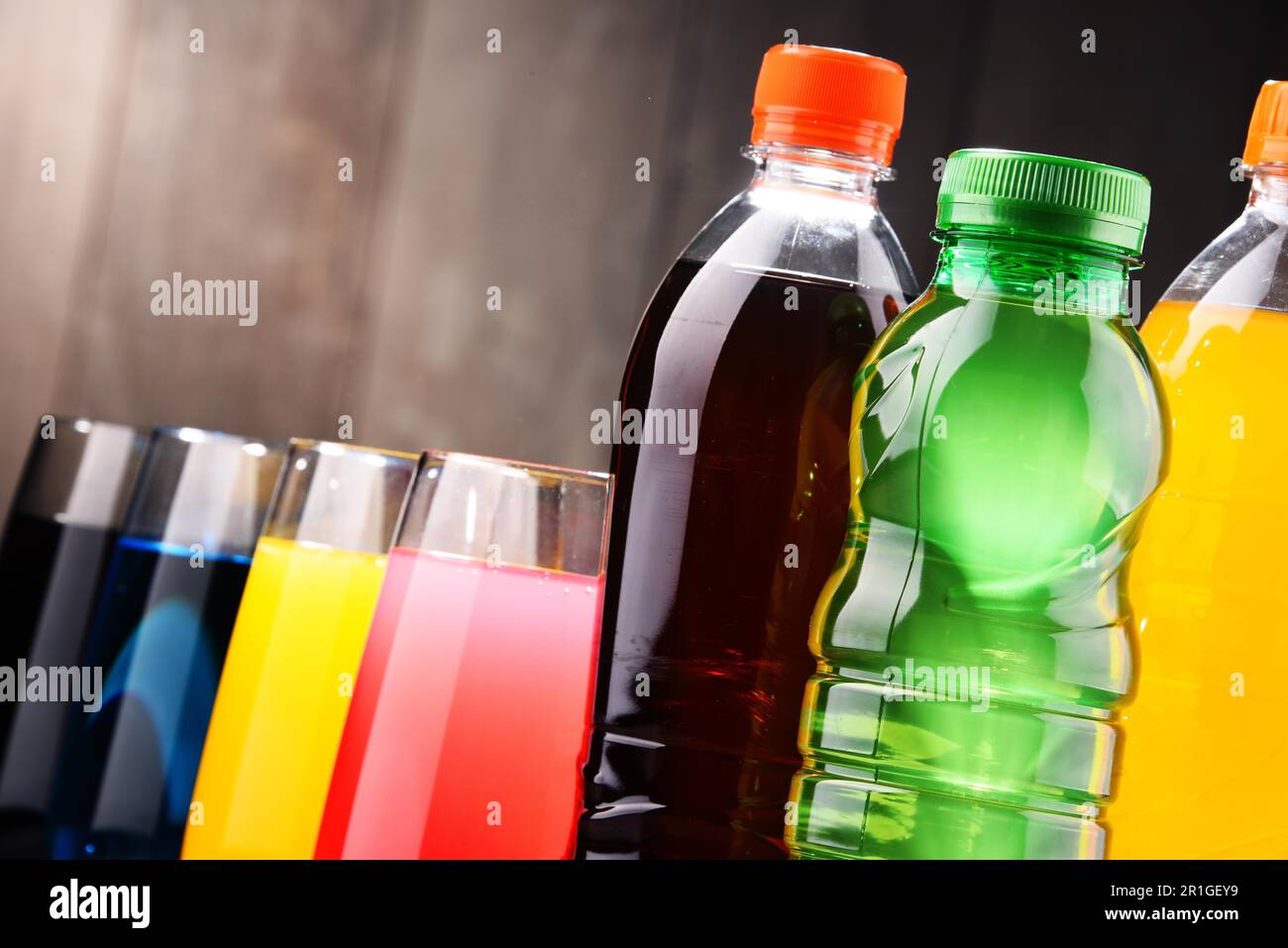Glasses and bottles of assorted carbonated soft drinks in variety of colors Stock Photo