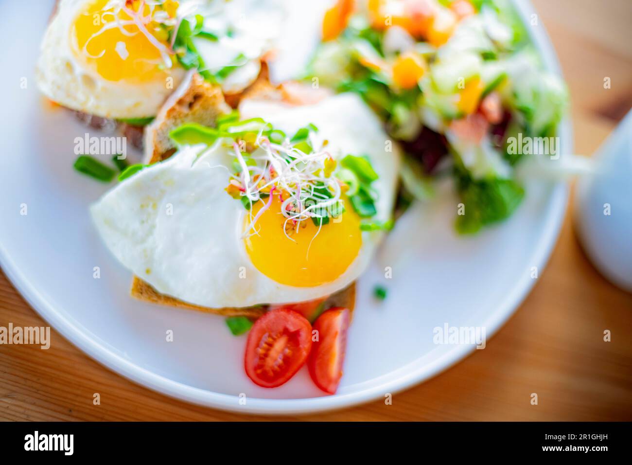 Breakfast with fried eggs on toasts on a restaurant table Stock Photo
