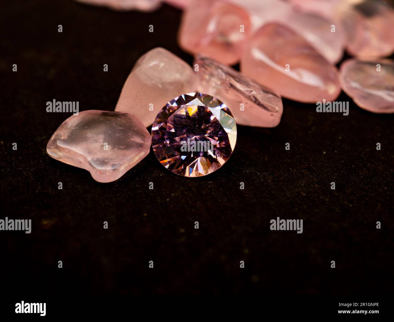 Rough pink colored diamond on black background Stock Photo