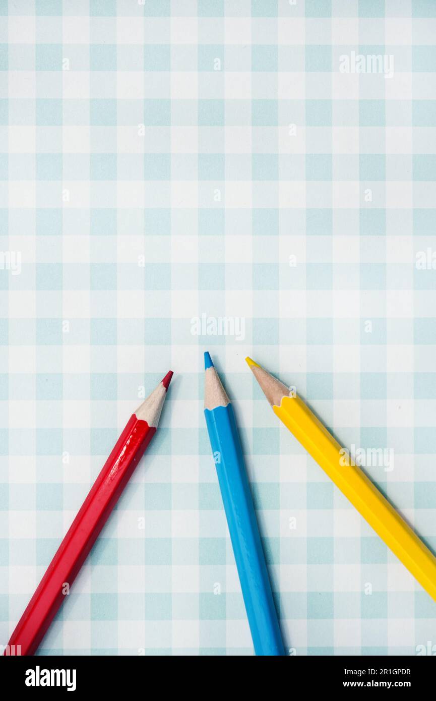 blue red and yellow pencils on a geometric background Stock Photo