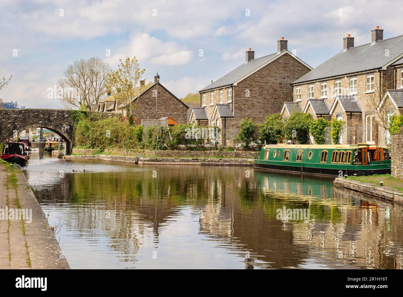 New houses reflected in Monmouthshire and Brecon Canal basin in Brecon (Aberhonddu), Powys, Wales, UK, Britain Stock Photo