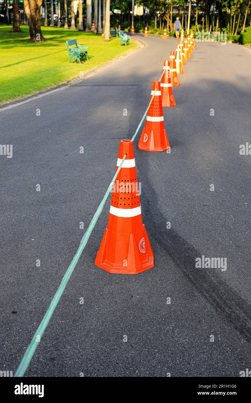 Row of orange fluorescent, reflex traffic cones on road. Stock Photo