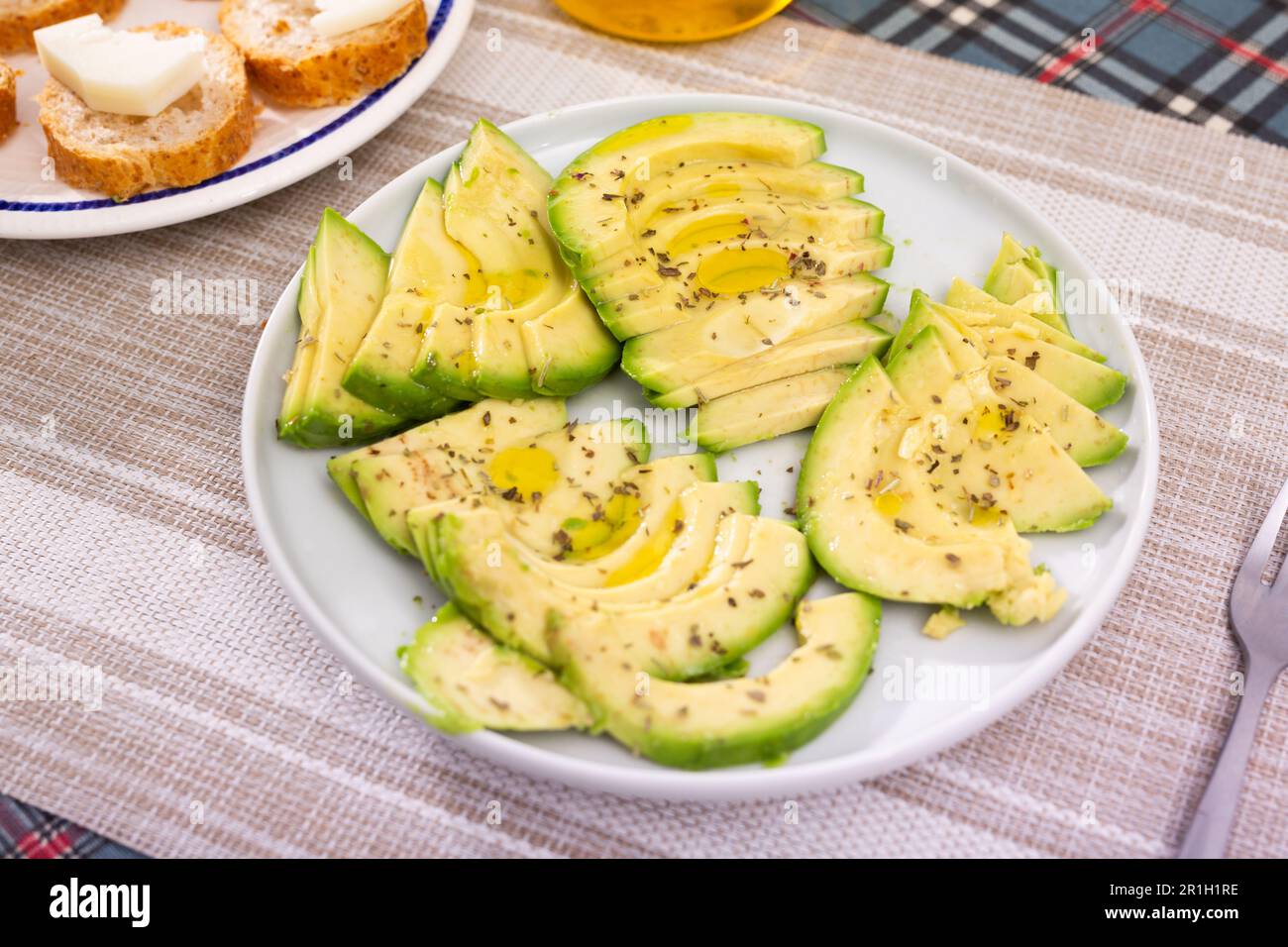 ripe avocado pulp cut into pieces sprinkled with lemon juice on a plate Stock Photo