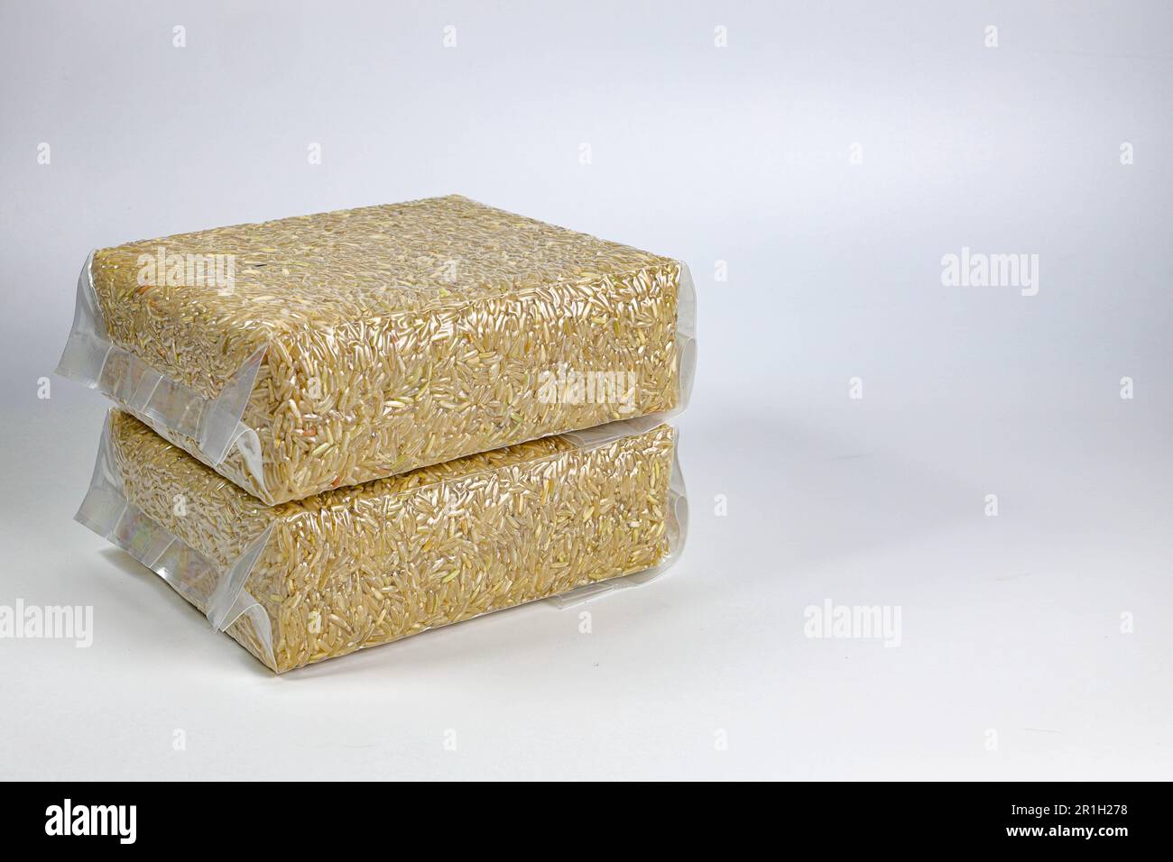 Brown Rice in transparent plastic vacuum sealed bag isolated on white