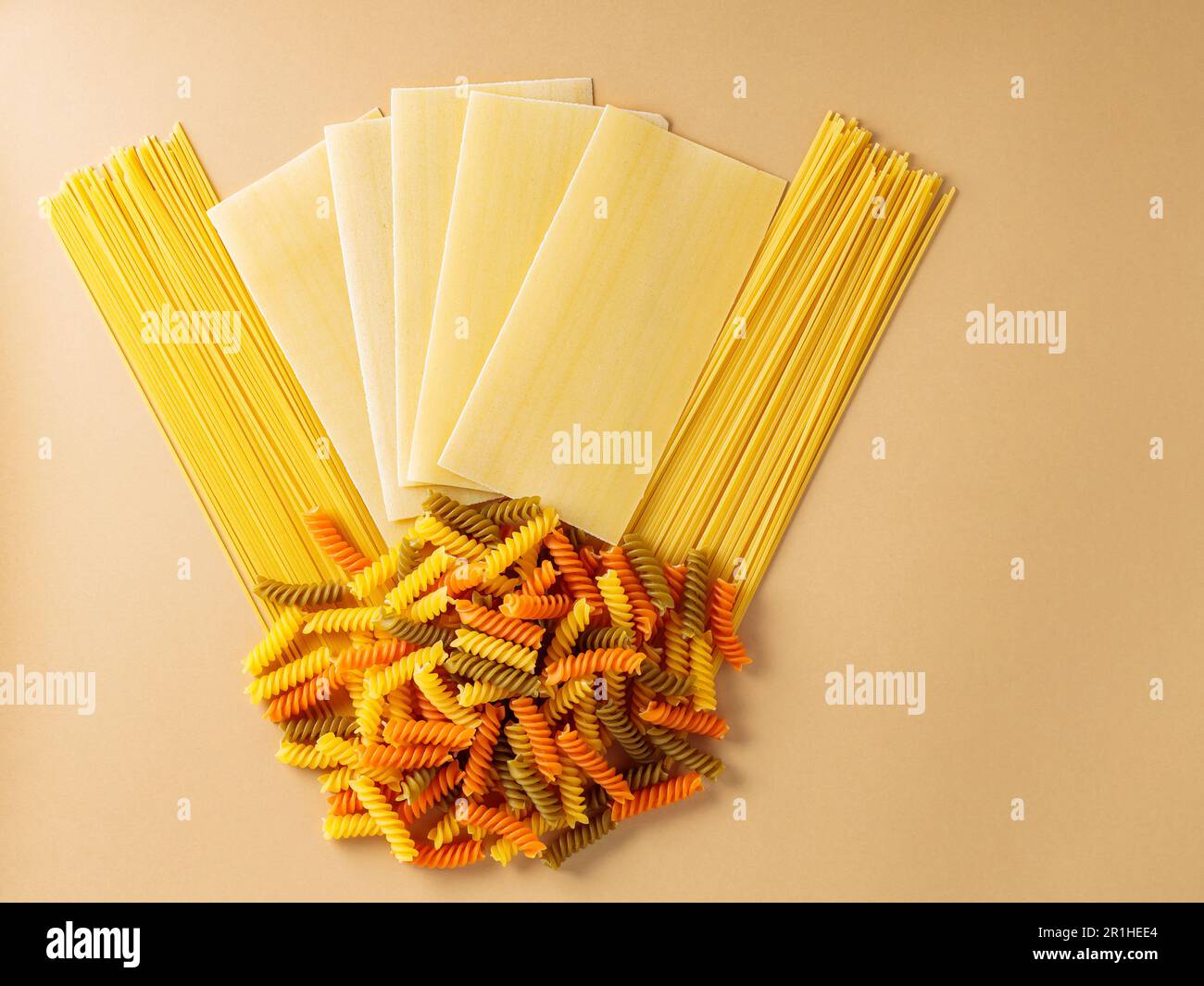 Pasta. Different types of raw pasta on a beige background. Creative