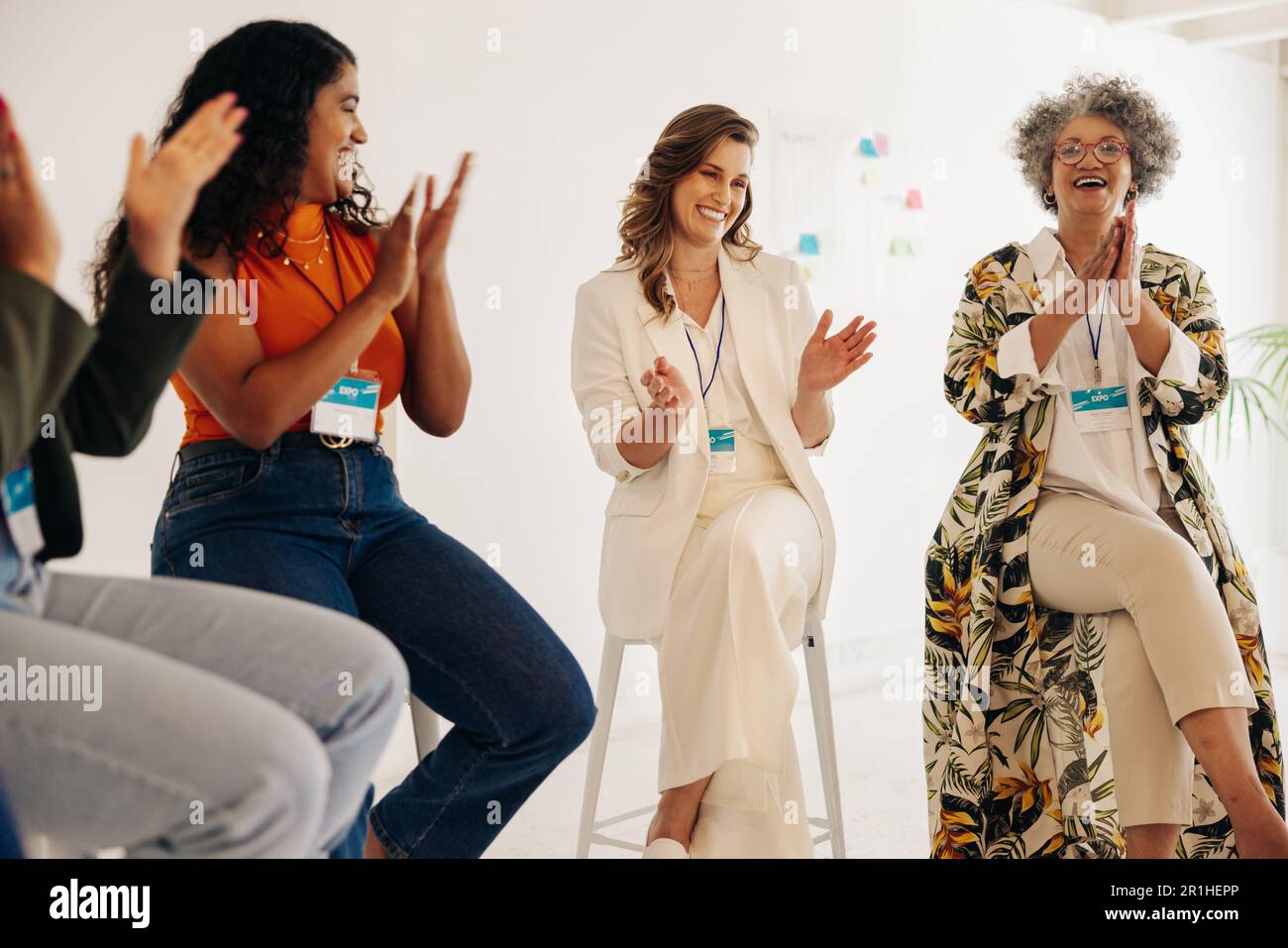 Happy businesswomen applauding during a conference meeting. Group of multicultural businesswomen celebrating their achievement. Successful businesswom Stock Photo