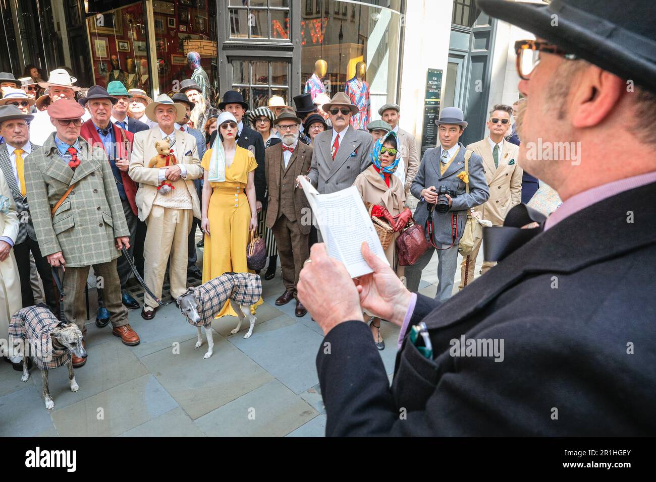 London, UK. 14th May, 2023. Alexander Larman, The Chap Magazine's Literary Editor, reads out to the assembled flaneurs. The annual Grand Flaneur Walk sees chaps and chapettes, dandies and quaintrelle in impeccable tailoring and style flanning and sauntering without purpose around St James' and surrounding areas of London. The walk always starts at the statue of socialite dandy Beau Brummell and slowly makes its way around the area. Credit: Imageplotter/Alamy Live News Stock Photo