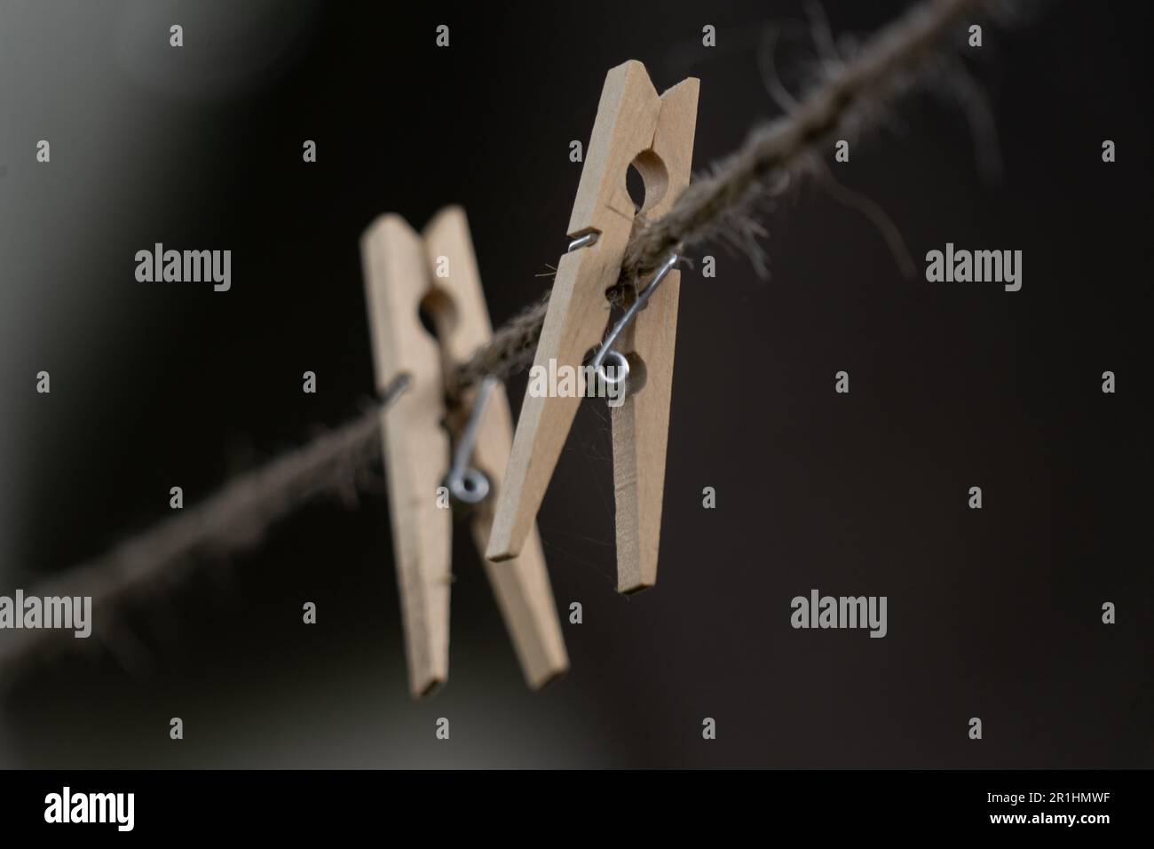 Wooden clothespins on an old washing line photographed with shallow focus Stock Photo