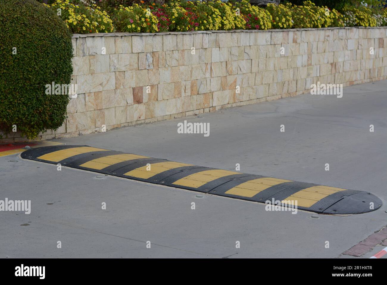 Striped rubber sleeping policeman on asphalt road Stock Photo Alamy