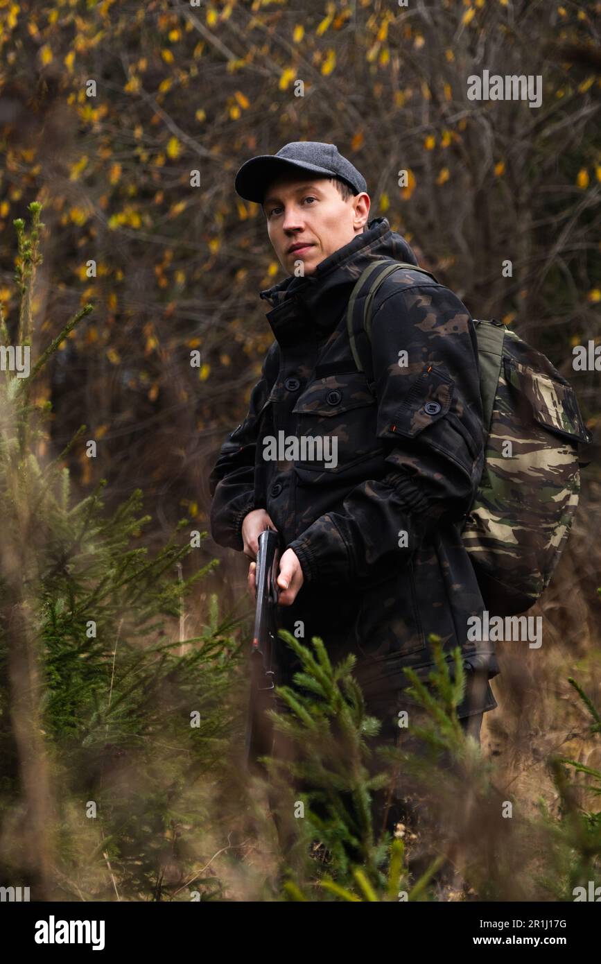 Hunter with a gun and a backpack in the forest. High quality photo Stock Photo