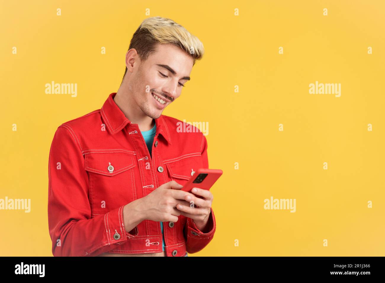 Happy gay man smiling while using the mobile Stock Photo