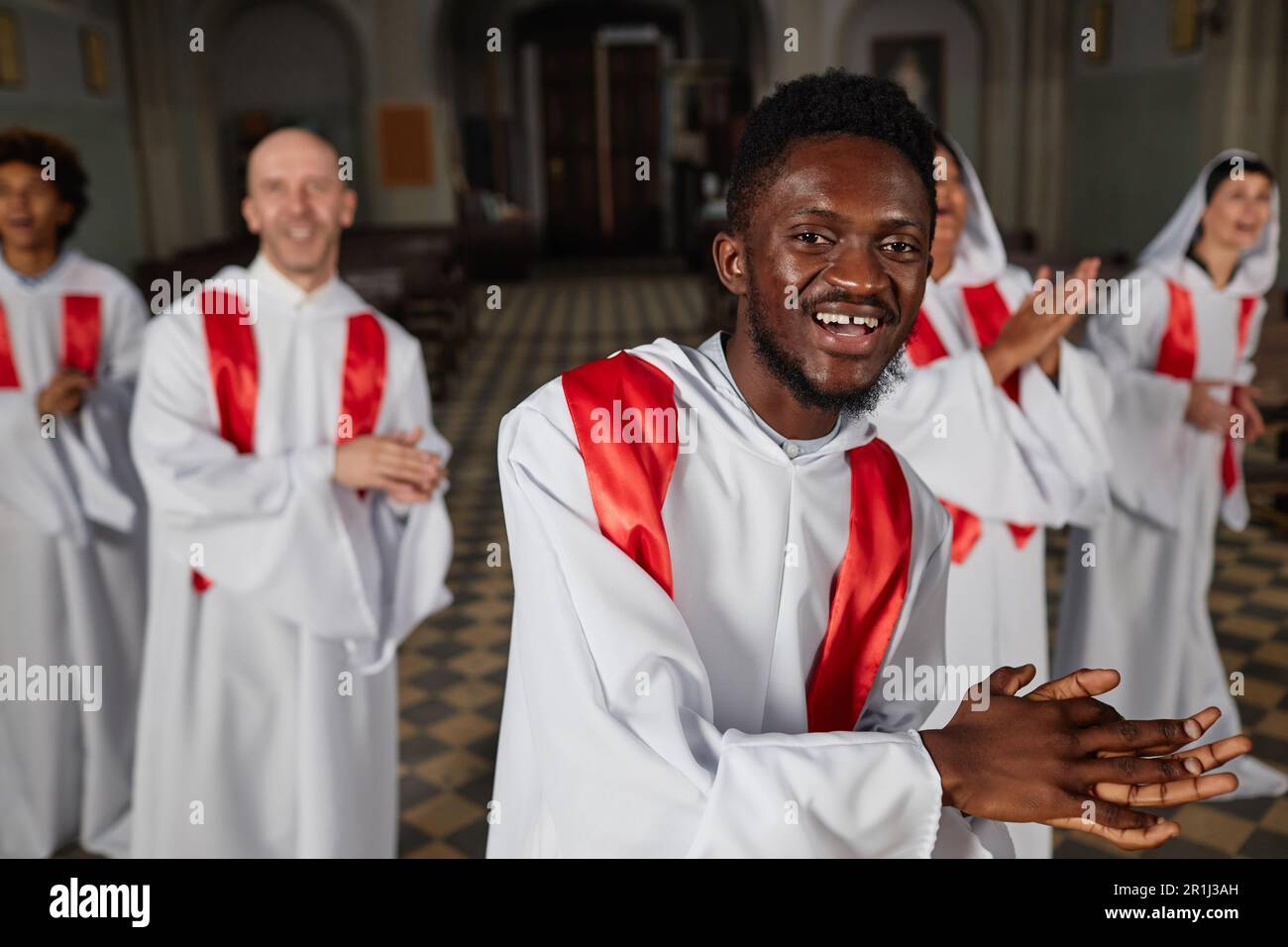 Group of people from church choir singing and clapping hands during