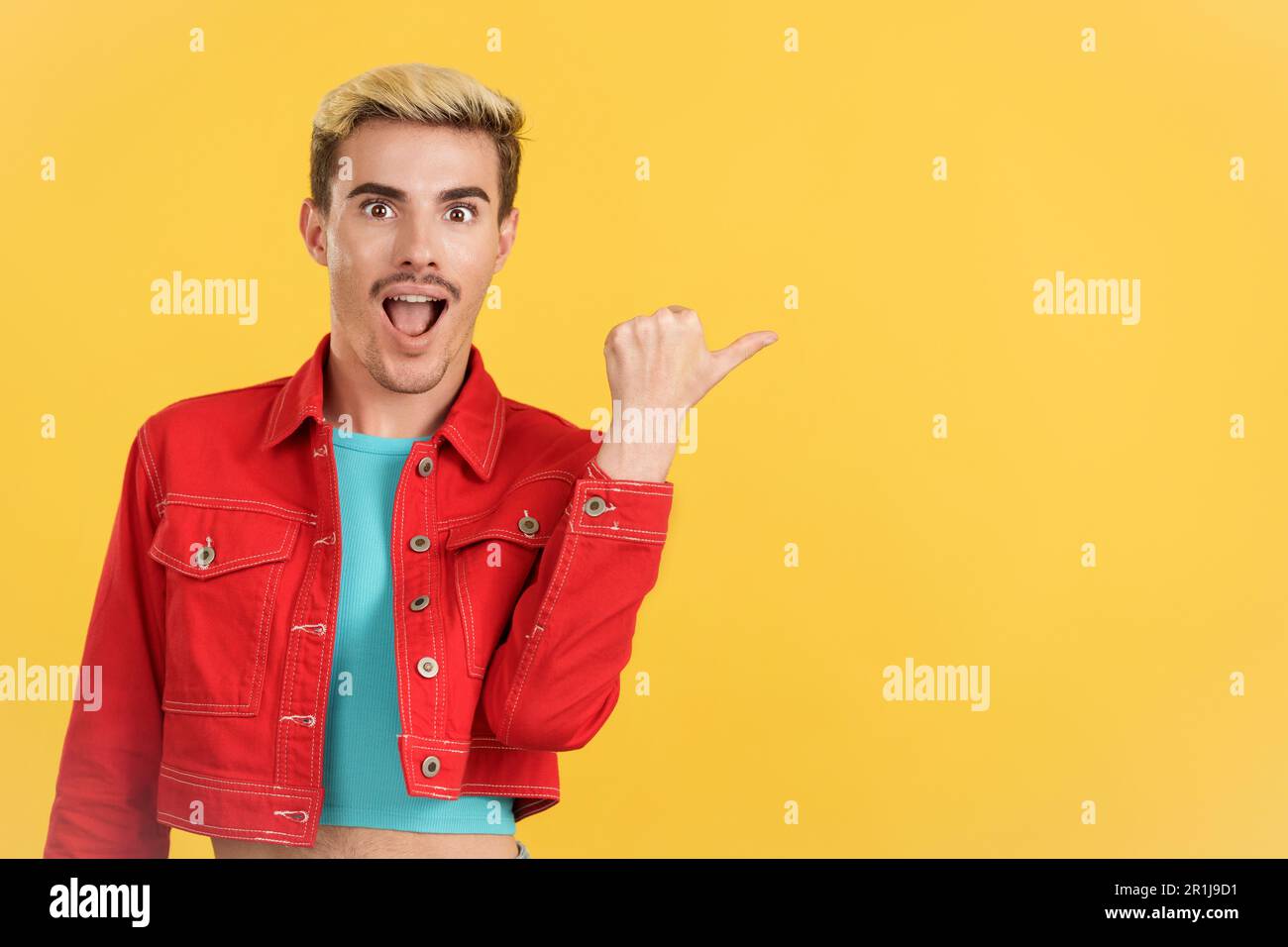 Surprised gay man pointing a blank space aside Stock Photo