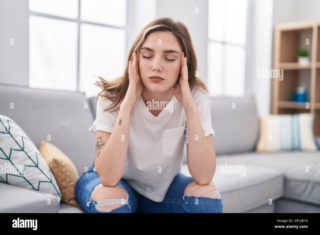 Young woman stressed sitting on sofa at home Stock Photo - Alamy