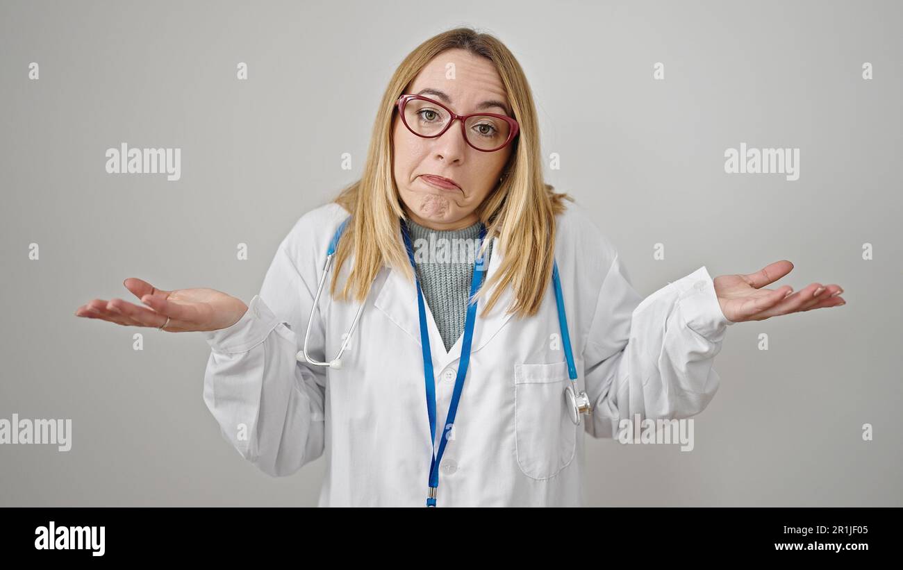 Young blonde woman doctor standing clueless over isolated white ...